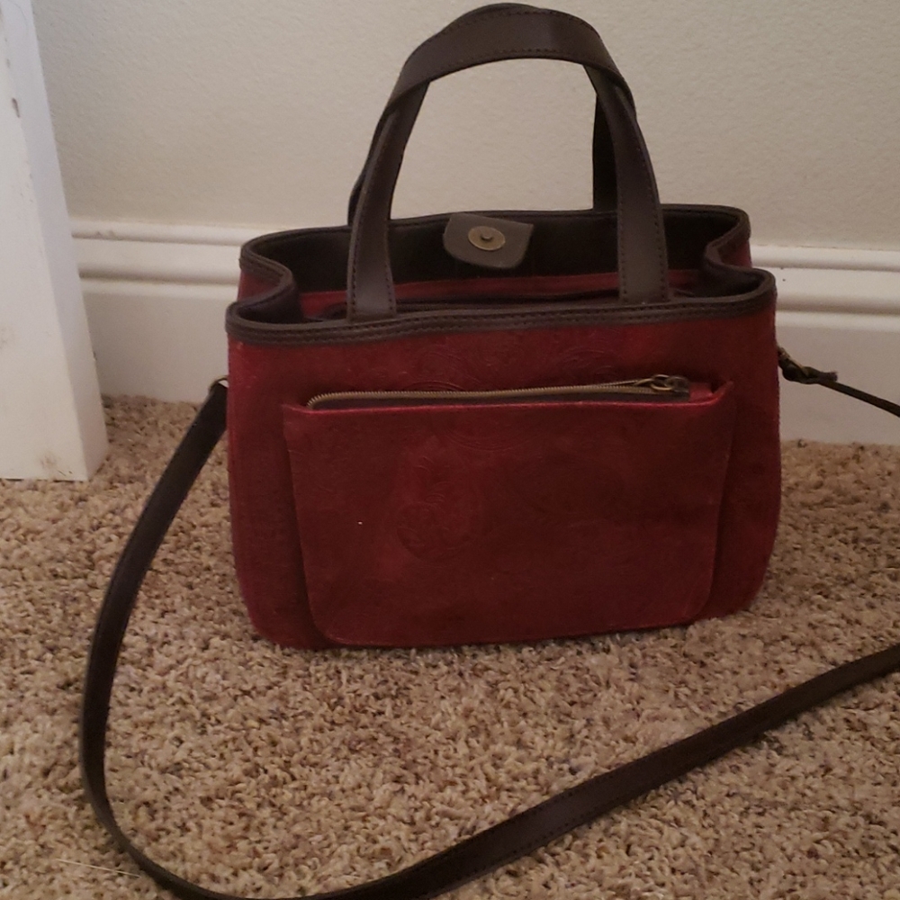 Purse with shoulder straps and hand straps.